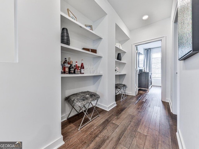 corridor featuring dark hardwood / wood-style flooring and built in shelves