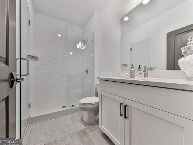 bathroom with vanity, toilet, and an enclosed shower