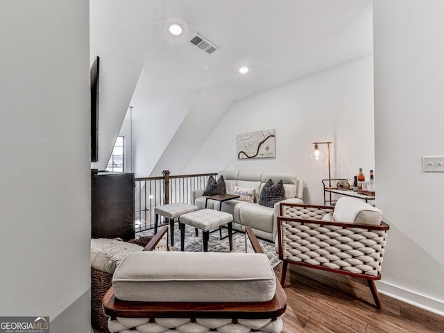 living room with hardwood / wood-style flooring and vaulted ceiling