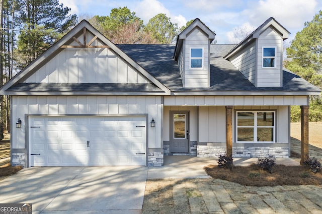 view of front of house with a garage, stone siding, board and batten siding, and concrete driveway