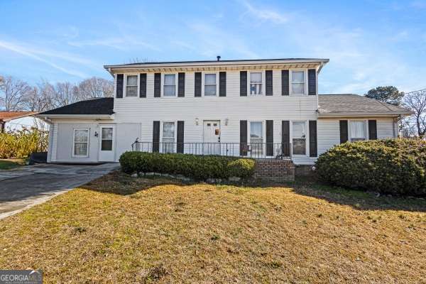 colonial-style house featuring a front yard