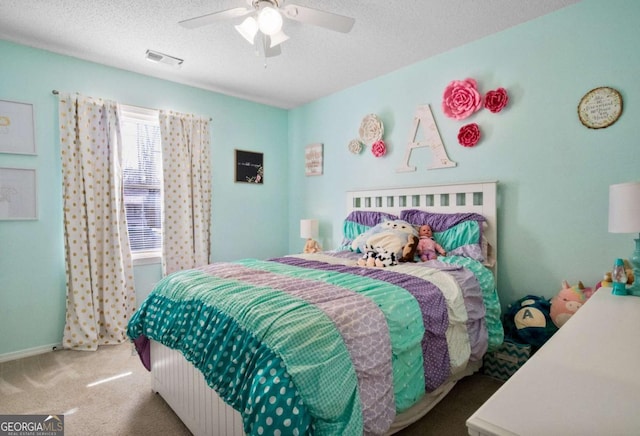 carpeted bedroom with ceiling fan and a textured ceiling