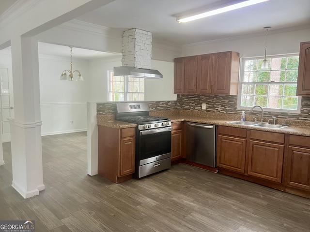 kitchen featuring decorative light fixtures, wood-type flooring, sink, decorative backsplash, and stainless steel appliances