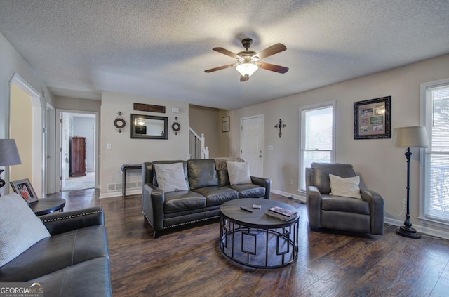 living room with ceiling fan, dark hardwood / wood-style floors, and a textured ceiling