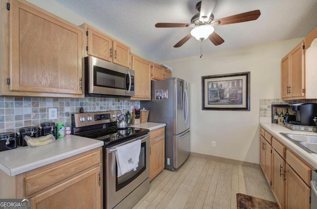 kitchen featuring appliances with stainless steel finishes, sink, backsplash, and a textured ceiling