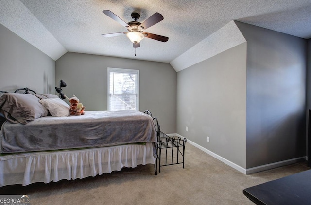 carpeted bedroom featuring a textured ceiling, vaulted ceiling, and ceiling fan