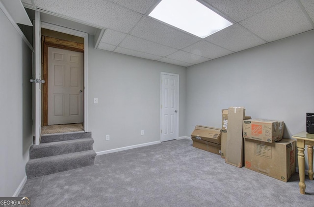 basement with carpet flooring and a paneled ceiling