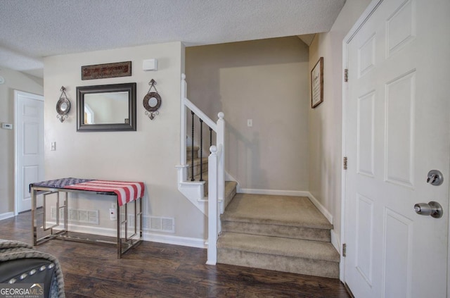 entrance foyer with dark hardwood / wood-style floors and a textured ceiling