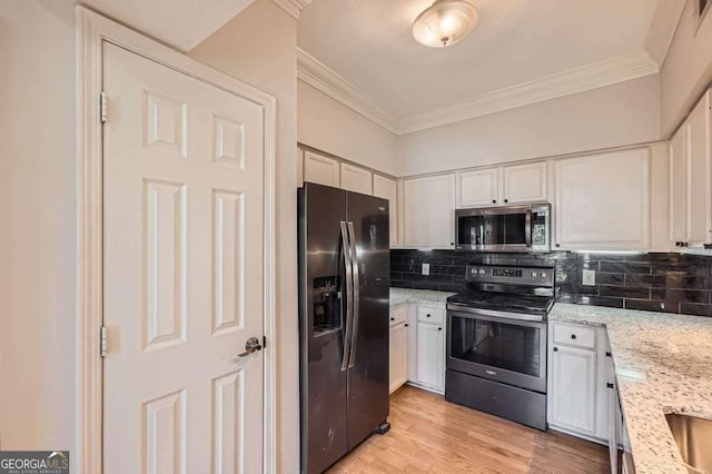 kitchen featuring light stone countertops, white cabinetry, appliances with stainless steel finishes, and decorative backsplash