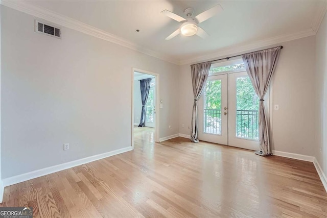 empty room featuring crown molding, ceiling fan, light wood-type flooring, and french doors