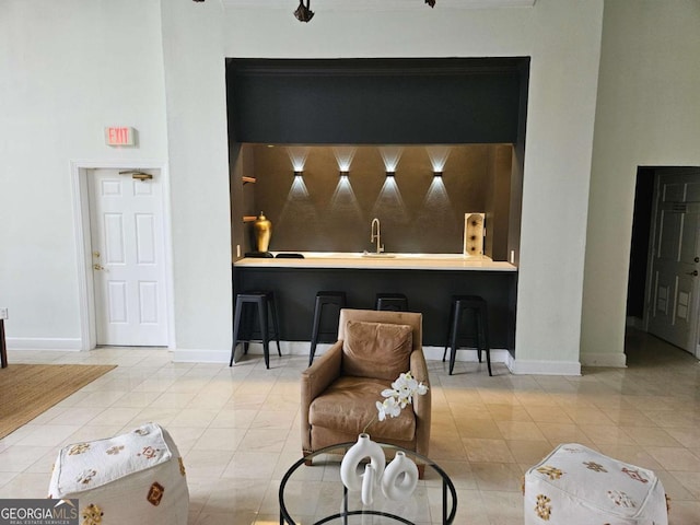 bar featuring sink and light tile patterned floors