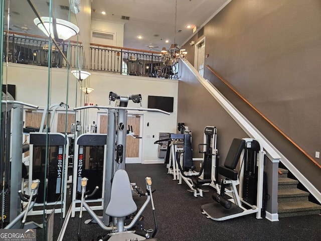 gym with ornamental molding and a chandelier