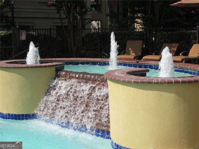 view of swimming pool with pool water feature