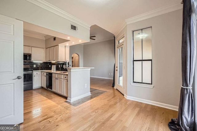 kitchen featuring tasteful backsplash, sink, kitchen peninsula, stainless steel appliances, and light hardwood / wood-style flooring