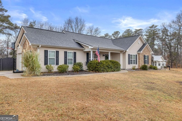 ranch-style house featuring a front yard, roof with shingles, and an attached garage