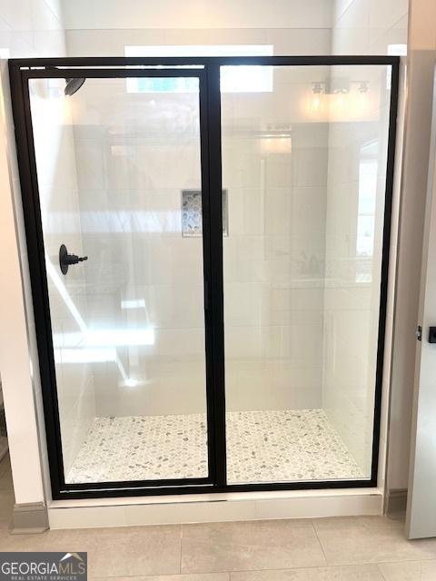 bathroom featuring a shower with shower door and tile patterned floors