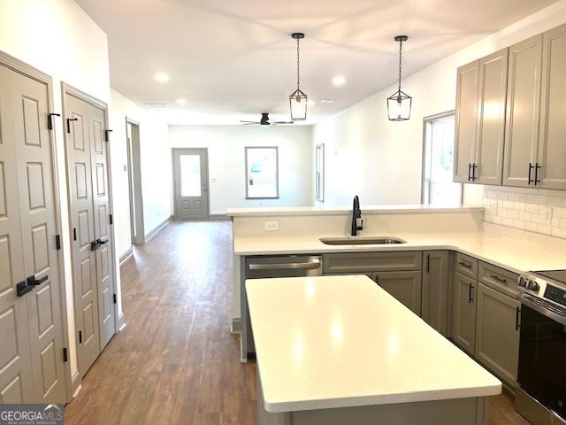 kitchen featuring a center island, sink, pendant lighting, and backsplash