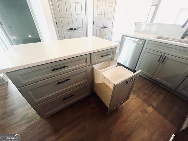 kitchen with gray cabinetry, sink, dark hardwood / wood-style floors, and dishwasher