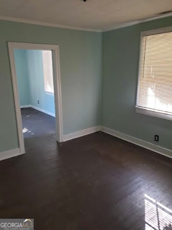 empty room with crown molding and dark hardwood / wood-style flooring