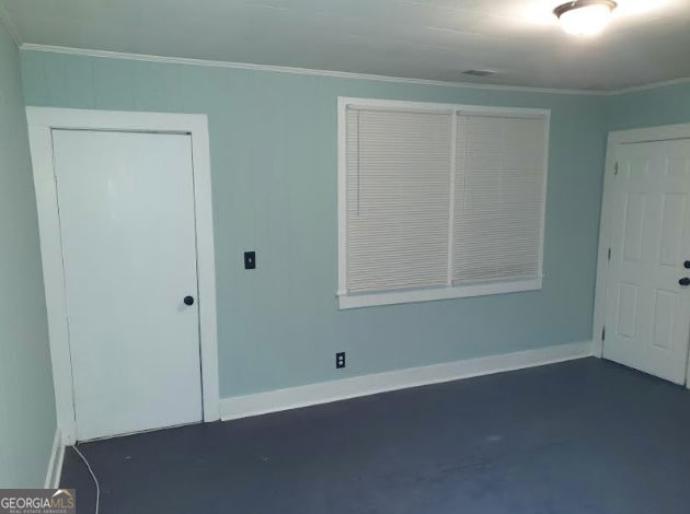 unfurnished room featuring crown molding