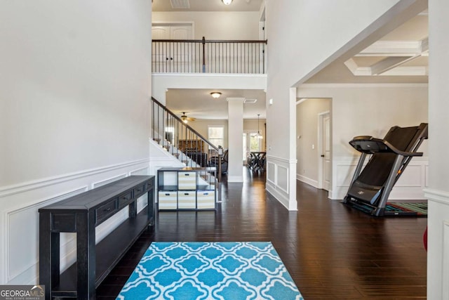 entryway featuring ornate columns, crown molding, dark hardwood / wood-style flooring, and beam ceiling