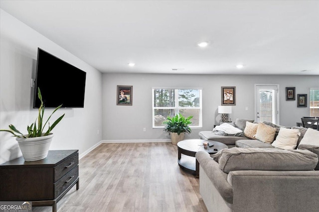 living room featuring light wood-style flooring, baseboards, a wealth of natural light, and recessed lighting