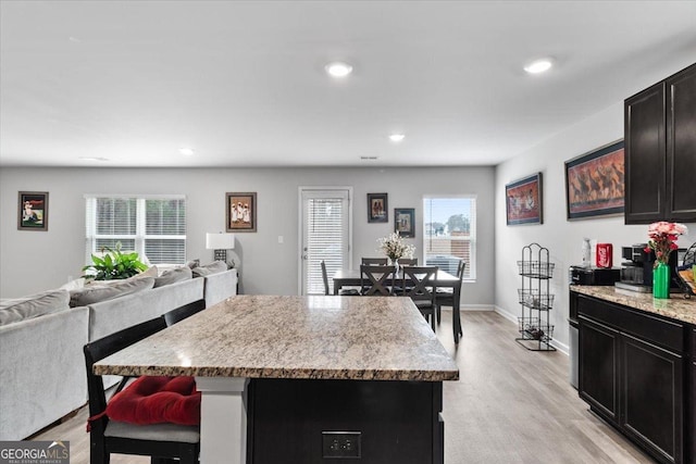 kitchen with light wood-style flooring, a kitchen island, open floor plan, and recessed lighting