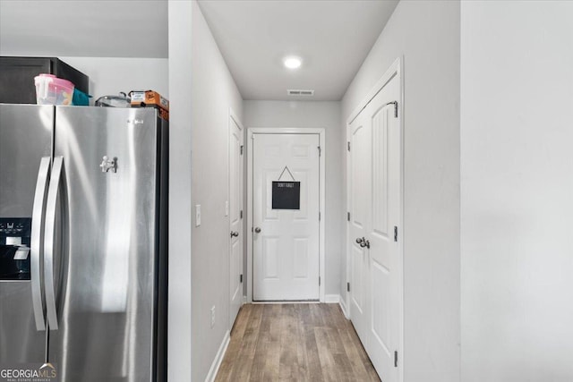 doorway to outside featuring visible vents, baseboards, and wood finished floors