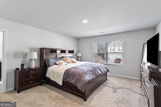 bedroom featuring visible vents, baseboards, and light colored carpet