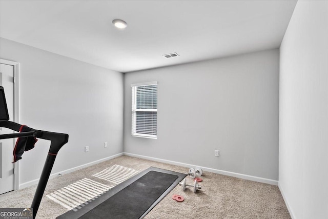 workout area with baseboards, visible vents, and light colored carpet