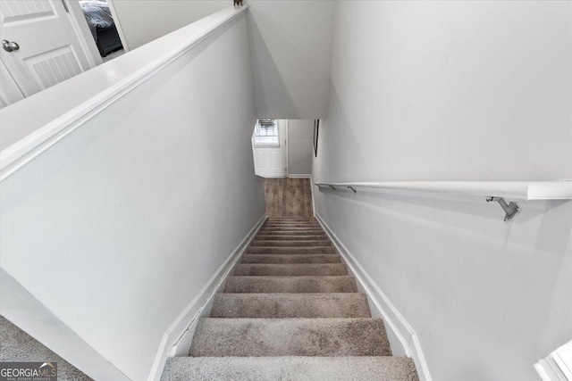 staircase featuring carpet floors and baseboards