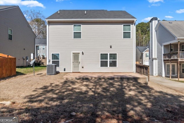 rear view of property featuring central AC and fence