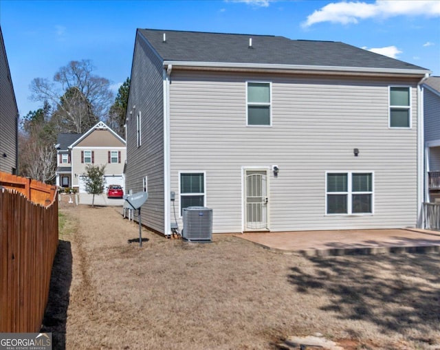 rear view of house with a patio, a lawn, cooling unit, and fence