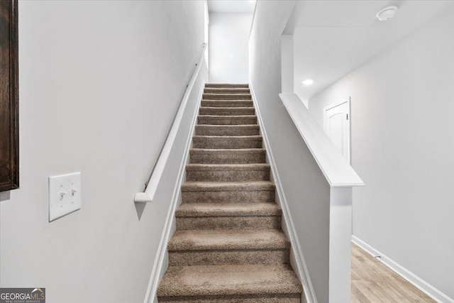 staircase with wood finished floors and baseboards