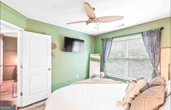 bedroom with ceiling fan and wood-type flooring