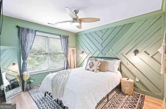 bedroom featuring multiple windows, hardwood / wood-style floors, and ceiling fan