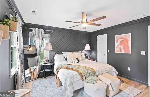 bedroom featuring crown molding, hardwood / wood-style floors, and ceiling fan