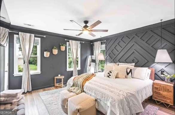 bedroom with ceiling fan, ornamental molding, and hardwood / wood-style floors