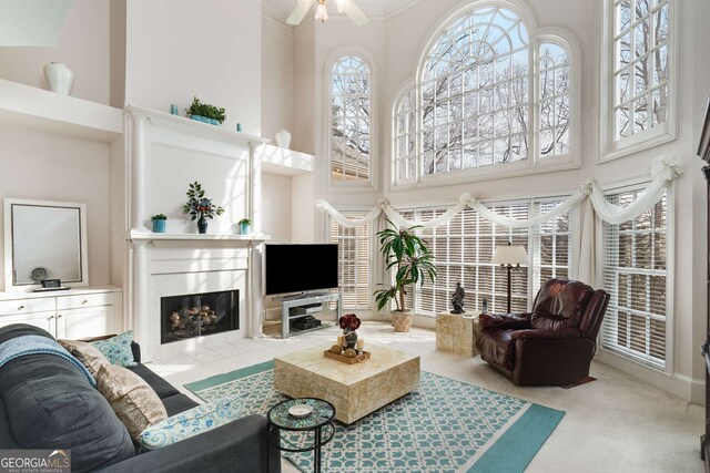 2290 Spencers Way, Stone Mountain, GA 30087 - carpeted living room featuring crown molding, a towering ceiling, ceiling fan, and a fireplace
