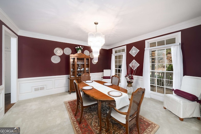 dining area with light carpet, crown molding, and a chandelier