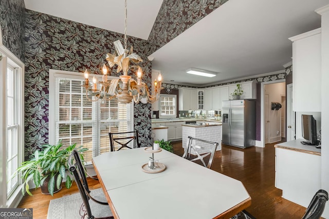 dining area featuring dark hardwood / wood-style flooring, ornamental molding, and an inviting chandelier