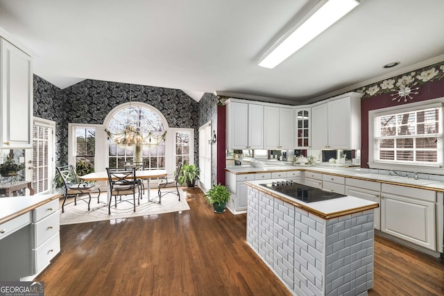 kitchen with dark wood-type flooring, sink, a center island, black electric stovetop, and white cabinets