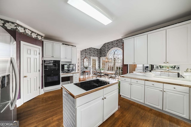 kitchen with white cabinets, dark hardwood / wood-style floors, and black appliances