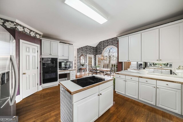 2290 Spencers Way, Stone Mountain, GA 30087 - kitchen featuring dark wood-type flooring, black appliances, wallpapered walls, light countertops, and white cabinets