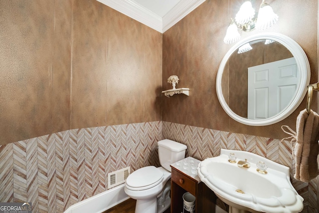 bathroom featuring an inviting chandelier, sink, ornamental molding, and toilet