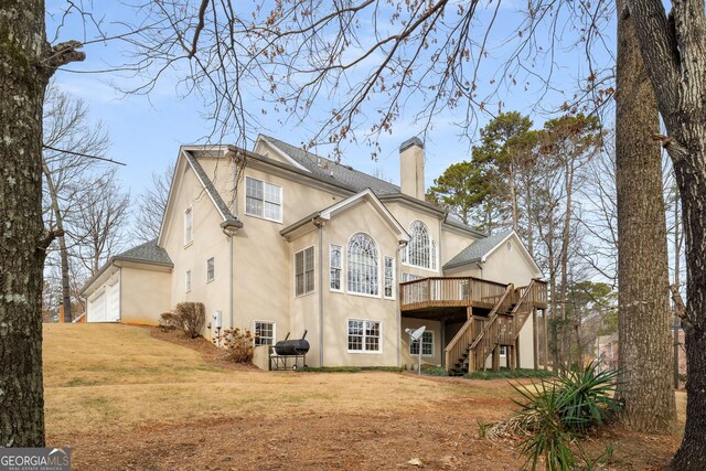 2290 Spencers Way, Stone Mountain, GA 30087 - rear view of house featuring a chimney, a deck, a lawn, stucco siding, and stairway