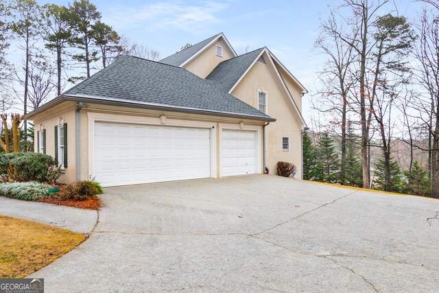 2290 Spencers Way, Stone Mountain, GA 30087 - view of property exterior featuring a garage, stucco siding, driveway, and roof with shingles