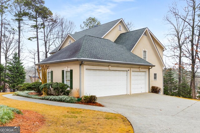 2290 Spencers Way, Stone Mountain, GA 30087 - view of side of home with stucco siding, driveway, an attached garage, and roof with shingles