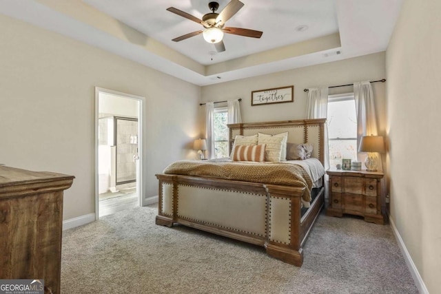 bedroom with carpet, a raised ceiling, ceiling fan, and ensuite bathroom