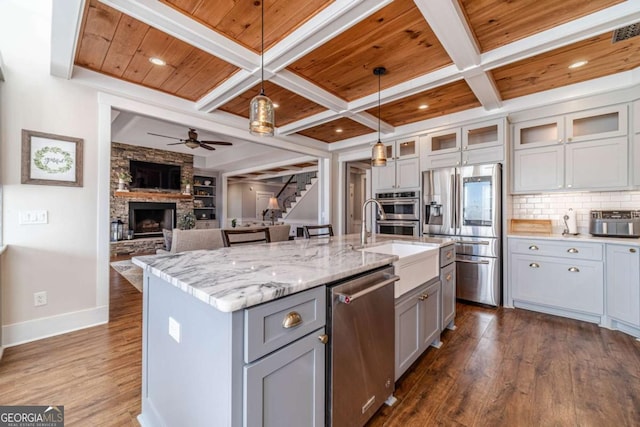 kitchen with appliances with stainless steel finishes, an island with sink, hanging light fixtures, coffered ceiling, and wood ceiling